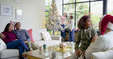Multigenerational diverse family decorating Christmas tree and enjoying cozy holiday