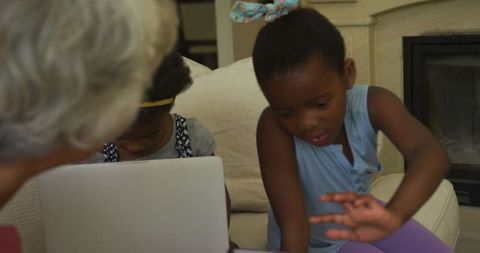 Grandmother Engaging with Granddaughters on Laptop for Learning Time
