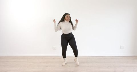 Energetic Woman Dancing Joyfully in Living Room