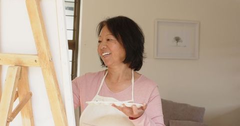 Senior chinese woman enjoying painting hobby at home