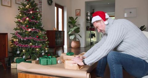 Man Wrapping Christmas Gifts in Cozy Living Room Setting