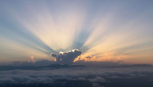 Sunburst Crepuscular Rays Through Cumulus Over Sea of Clouds and Mountain Ridge at Dawn