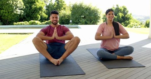 Joyful Couple Practicing Yoga Outdoors on Sunny Deck
