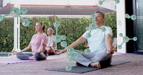 Mature Adults Meditating on Patio During Morning Outdoor Yoga Session for Mindfulness