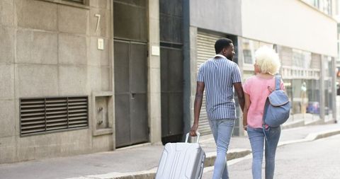 Diverse Couple Walking on City Stroll Holding Luggage - Download Free Stock Images Pikwizard.com