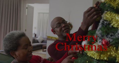 African American Couple Decorating Christmas Tree with Greetings