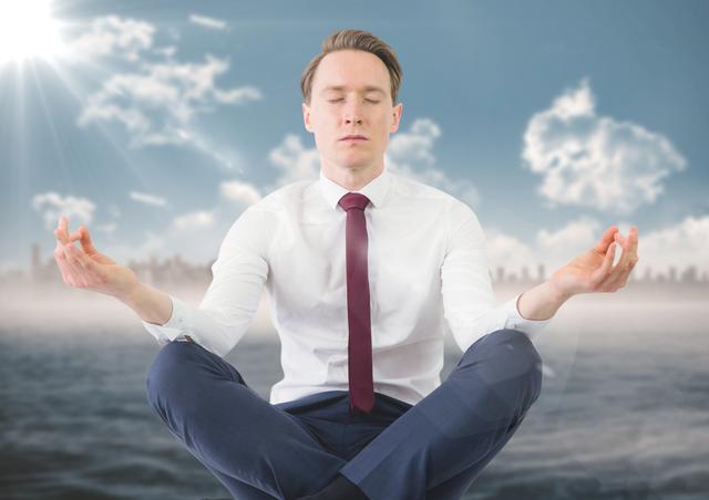 Digital composite of Business man meditating against water and blurry skyline with flare