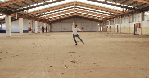 Caucasian Dancer Moving Expressively in Spacious Warehouse