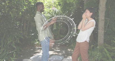 Romantic Garden Surprise: Man Presenting White Bouquet, Woman Covering Mouth in Joy