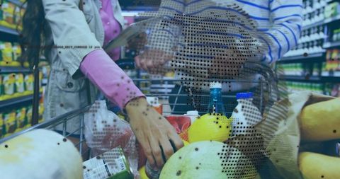 Couple filling shopping cart with melons, milk and groceries in busy supermarket aisle