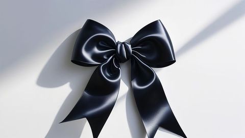 Elegant glossy satin ribbon bow on white surface