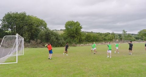 Teens Engaged in Competitive Soccer Match on Lush Field