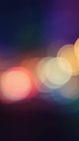 Vertical bokeh lights drifting with rainbow glow, dynamic blurred background video