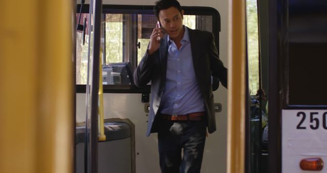 Biracial man standing in city bus talking on smartphone. Communication, transport, city living and lifestyle, unaltered.