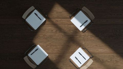 Geometric workspace arrangement with chairs and notebooks for creativity