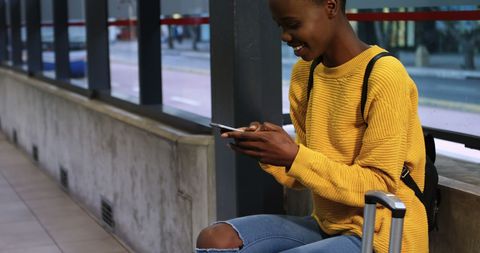 Young Woman Checking Phone at Public Transport Shelter - Download Free Stock Images Pikwizard.com