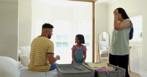 Family Packing Activity in Bright Bedroom Before Travel