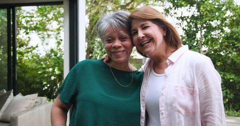 Senior Mother and Daughter Embracing at Home Entrance