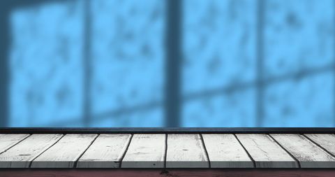 Wooden platform with blue window shadow and raindrops