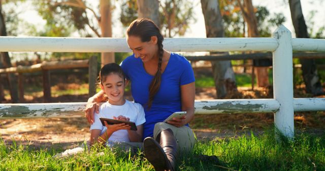 Mother and daughter enjoying digital devices outdoors in park - Download Free Stock Images Pikwizard.com