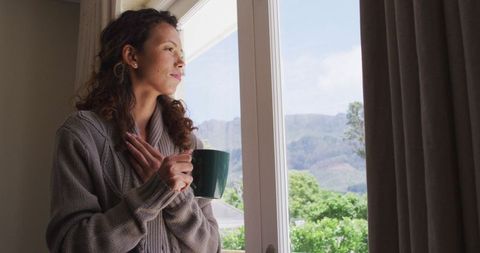 Thoughtful Woman with Coffee Gazing Out the Window