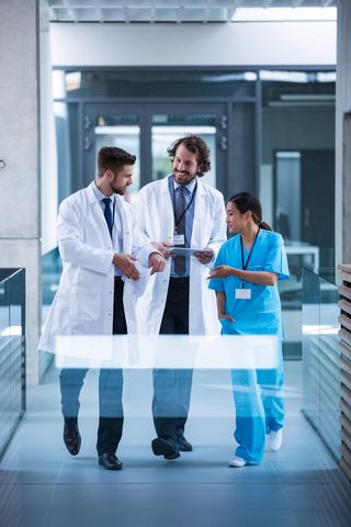 Medical Team Discussing Patient Care in Hospital Corridor - Download Free Stock Images Pikwizard.com
