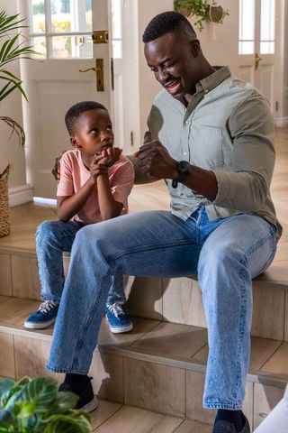 African american father and son bonding on home steps sharing conversation and laughter