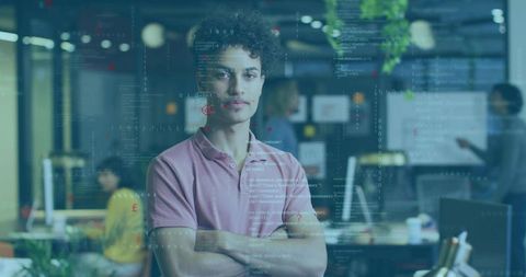 Young software engineer standing with arms crossed in open office with digital code overlay