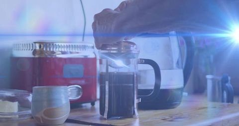Person Brewing Coffee with French Press on Rustic Kitchen Counter