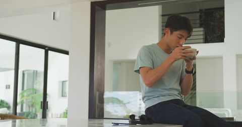 Asian Teenager Enjoying Morning Breakfast in Modern Kitchen