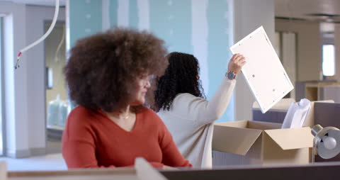 Diverse Team Unpacking Boxes in Modern Office