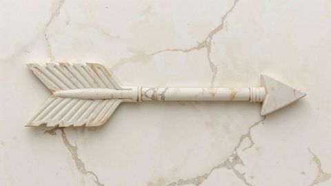 Decorative Arrow Resting on Marble with Textured Fletching