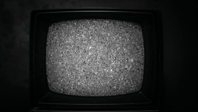 Vintage CRT Television Showing Static in Dimly Lit Room