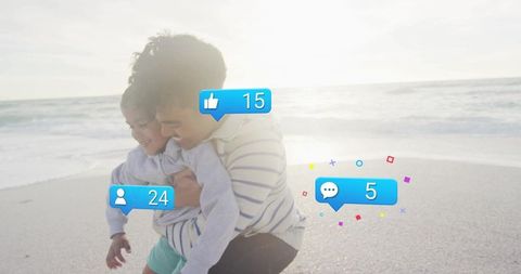 Father and son hugging on sunny beach with social media like, comment and follower bubbles