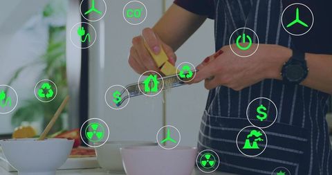 Grating lemon zest over pastel bowls while wearing striped apron with green eco icons