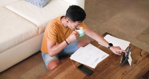 Asian Man Evening Casual with Tablet and Coffee In Cozy Living Room