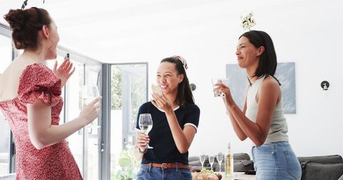 Diverse Female Graduates Celebrating with Toast in Sunny Dining Room