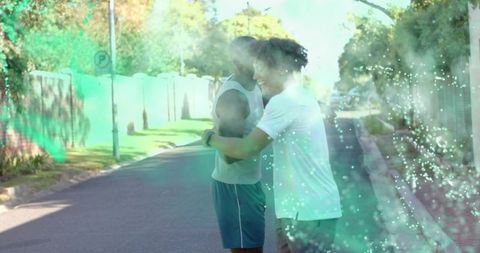 Male friends hugging on sunlit suburban street with green mist and surreal light overlay
