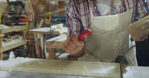 Experienced carpenter crafting wooden panel in workshop