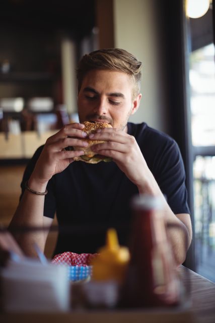 Man eating burger in restaurant