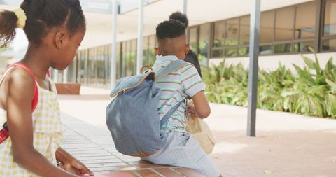 Diverse Schoolchildren with Backpacks in Vibrant Schoolyard Setting