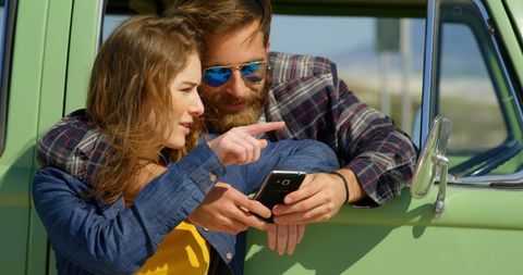 Happy Couple Exploring Travel Plans Outdoors By Van
