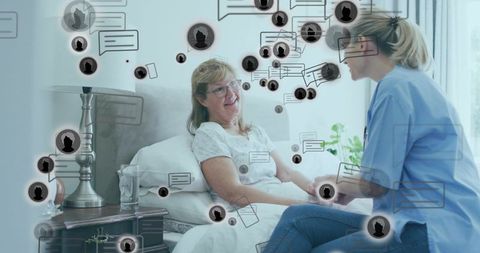 Holding senior hand at bedside showing telehealth chat icons, nurse support