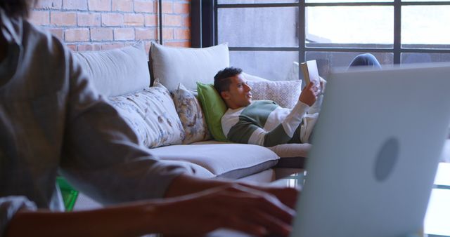 Young Man Relaxing on Couch Using Tablet in Modern Living Room - Download Free Stock Images Pikwizard.com