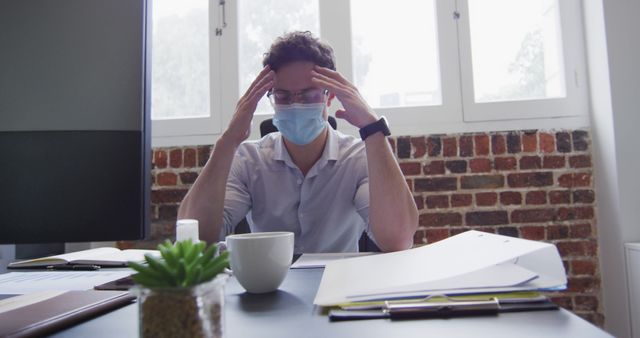 Frustrated Businessman Wearing Face Mask Working at Office Desk - Download Free Stock Images Pikwizard.com