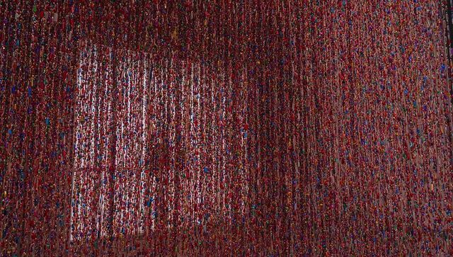 Vibrant Multicolored Hanging Bead Curtain Installation Revealing Lit Window and Gallery Corner