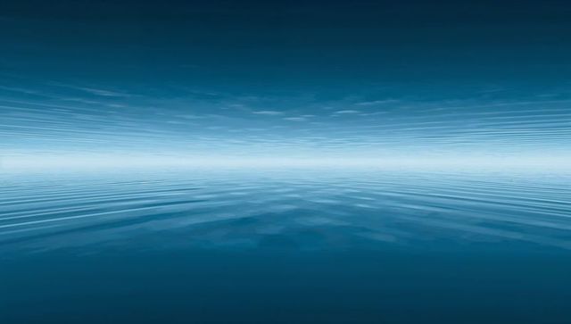 Endless calm blue horizon with symmetrical reflective sea and minimal light band