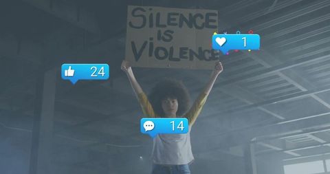 Activist raising silence is violence placard with social media reaction bubbles in urban garage