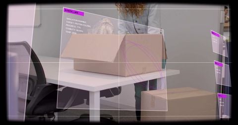 Mature woman unboxing parcel at modern office desk with augmented reality panels