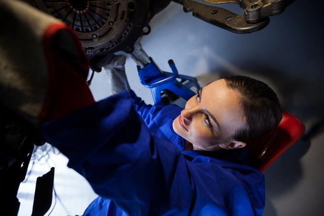 Female mechanic repairing a car at the repair garage